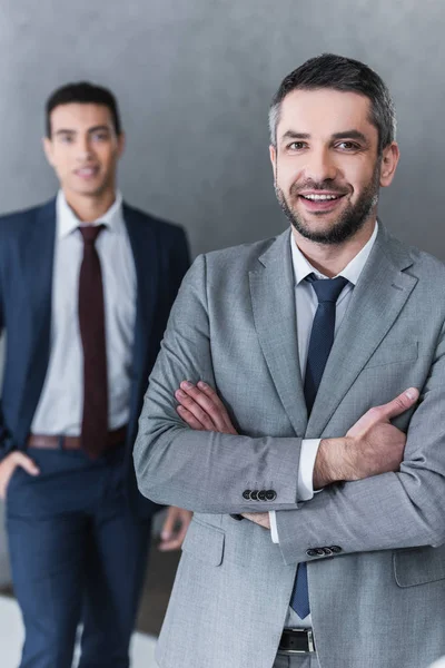 Confiado Hombre Negocios Pie Con Los Brazos Cruzados Sonriendo Cámara — Foto de Stock