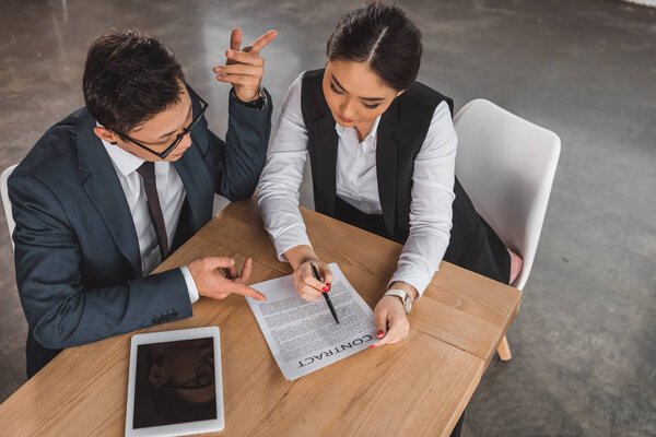 high angle view of professional young business colleagues discussing contract in office