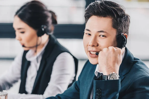 Handsome Young Man Headset Smiling Camera While Working Female Colleague — Stock Photo, Image