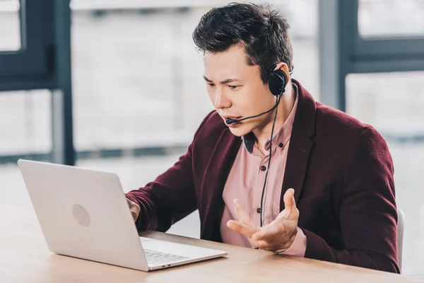 Känslomässiga Ung Asiatisk Affärsman Headsetet Använder Laptop Arbetsplatsen — Stockfoto