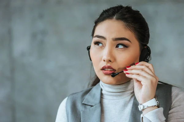 Serio Joven Asiático Mujer Negocios Auriculares Mirando Lejos Gris — Foto de Stock