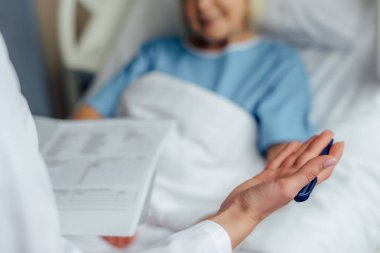 tanı tutarak ve hasta hastane yatağında yalan danışmanlık Doktor görünümünü kırpılmış 