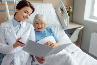 güzel kadın doktor holding tanı gülümseyen ve hastanede yatan kadın kıdemli danışmanlık