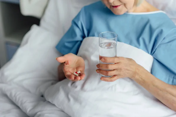 Vista Recortada Mujer Mayor Acostada Cama Sosteniendo Píldoras Con Vaso — Foto de Stock