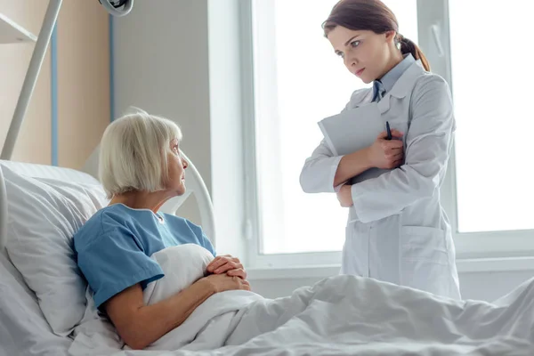 Mujer Doctora Sosteniendo Diagnóstico Visitando Mujer Mayor Acostada Cama Hospital —  Fotos de Stock