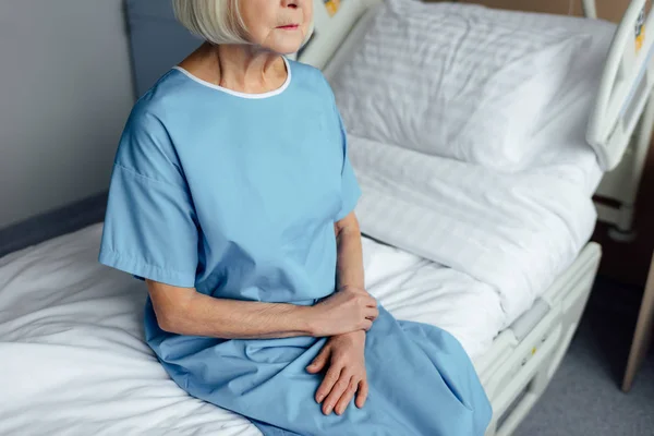 Vista Cortada Mulher Idosa Com Mãos Dobradas Sentadas Cama Hospital — Fotografia de Stock