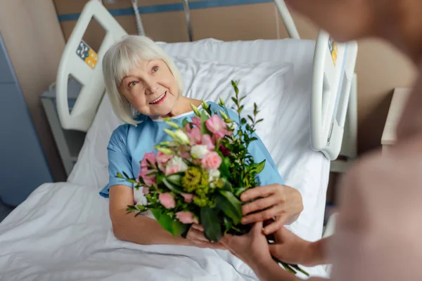 Hija Presentando Flores Feliz Mujer Mayor Acostada Cama Hospital — Foto de Stock