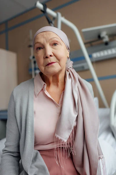 Krebskranke Seniorin Sitzt Krankenhaus Auf Bett Und Blickt Kamera — Stockfoto