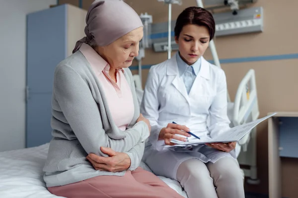 担心女医生举行诊断和咨询不安的老年妇女癌症在医院 — 图库照片