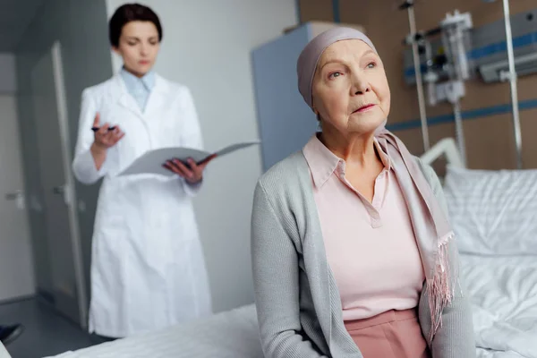 Senior Kobieta Chustę Rakiem Siedząc Łóżku Szpitalnym Lekarka Gospodarstwa Diagnozy — Zdjęcie stockowe