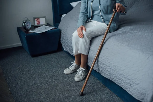 Cropped View Senior Woman Sitting Holding Walking Stick Bedroom — Stock Photo, Image