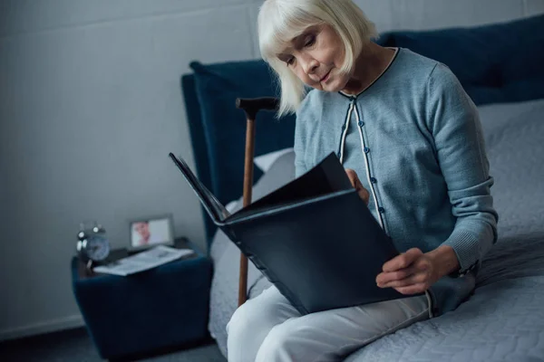 Sad Senior Woman Sitting Bed Looking Photo Album Home — Stock Photo, Image