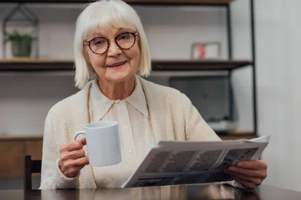 Zâmbind Femeie Vârstă Stând Masă Citind Ziarul Timp Bea Cafea — Fotografie, imagine de stoc