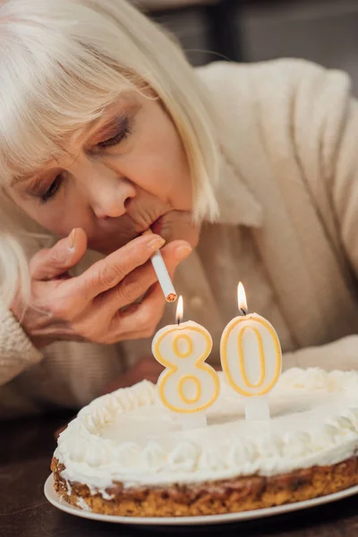 Vista Perto Mulher Sênior Acendendo Cigarro Velas Acesas Bolo Aniversário — Fotografia de Stock