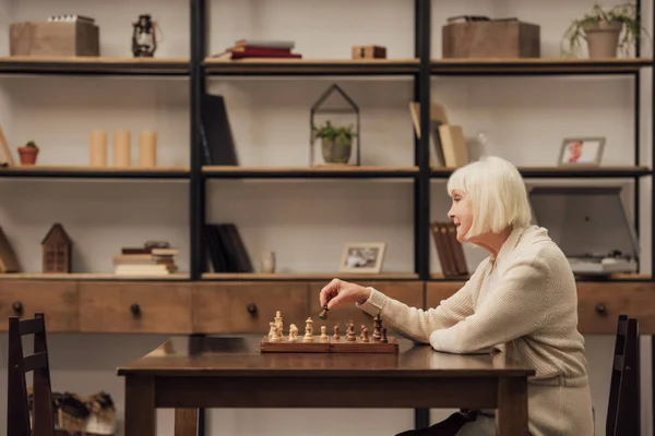Селективное Внимание Пожилой Женщины Сидящей Столом Играющей Шахматы Гостиной — стоковое фото