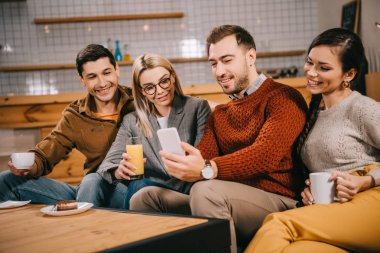 cheerful group of friends smiling while taking selfie  clipart