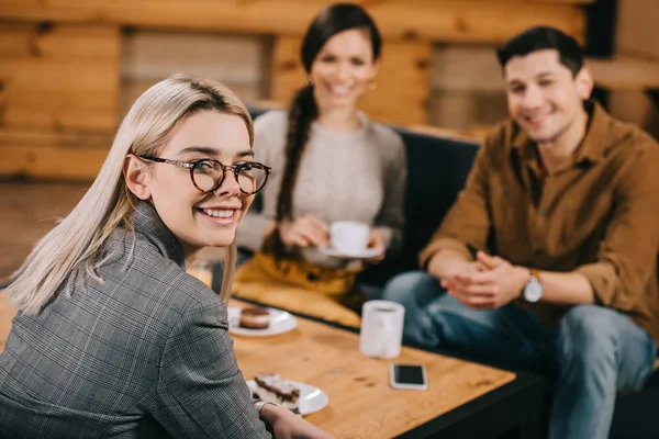 Messa Fuoco Selettiva Donna Sorridente Occhiali Con Gli Amici Sfondo — Foto Stock