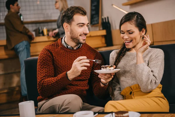 sürpriz kadına bakarak ve pasta kafede tutan yakışıklı adam