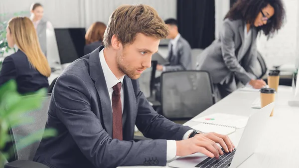 Skoncentrowane Młody Biznesmen Korzysta Laptopa Podczas Pracy Otwartej Przestrzeni Biura — Zdjęcie stockowe