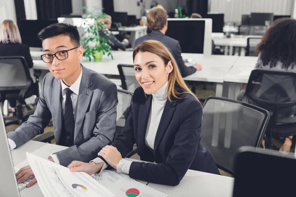 Junge Multiethnische Geschäftskollegen Lächeln Die Kamera Während Sie Arbeitsplatz Zusammensitzen — Stockfoto