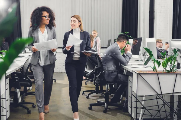 Bela Sorrindo Jovens Empresárias Multirraciais Segurando Papéis Andando Escritório — Fotografia de Stock