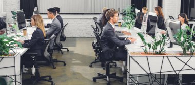 açık alan Office masaüstü bilgisayarlarla çalışan profesyonel genç iş adamları 