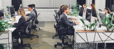 professional young businesspeople working with desktop computers in open space office  clipart