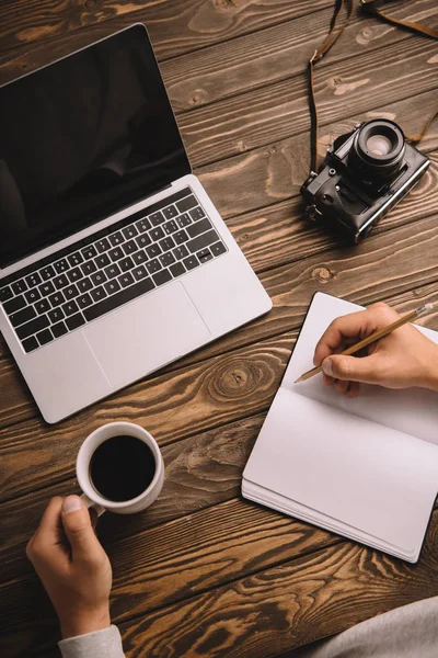 Vista Recortada Fotógrafo Masculino Escrevendo Notebook Mesa Com Xícara Café Imagens Royalty-Free