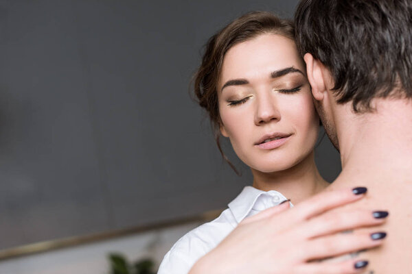 young girl enjoying by gentle touch of guy with closed eyes