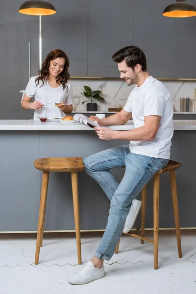 Handsome Man Reading Newspaper Attractive Woman Kitchen — Stock Photo, Image