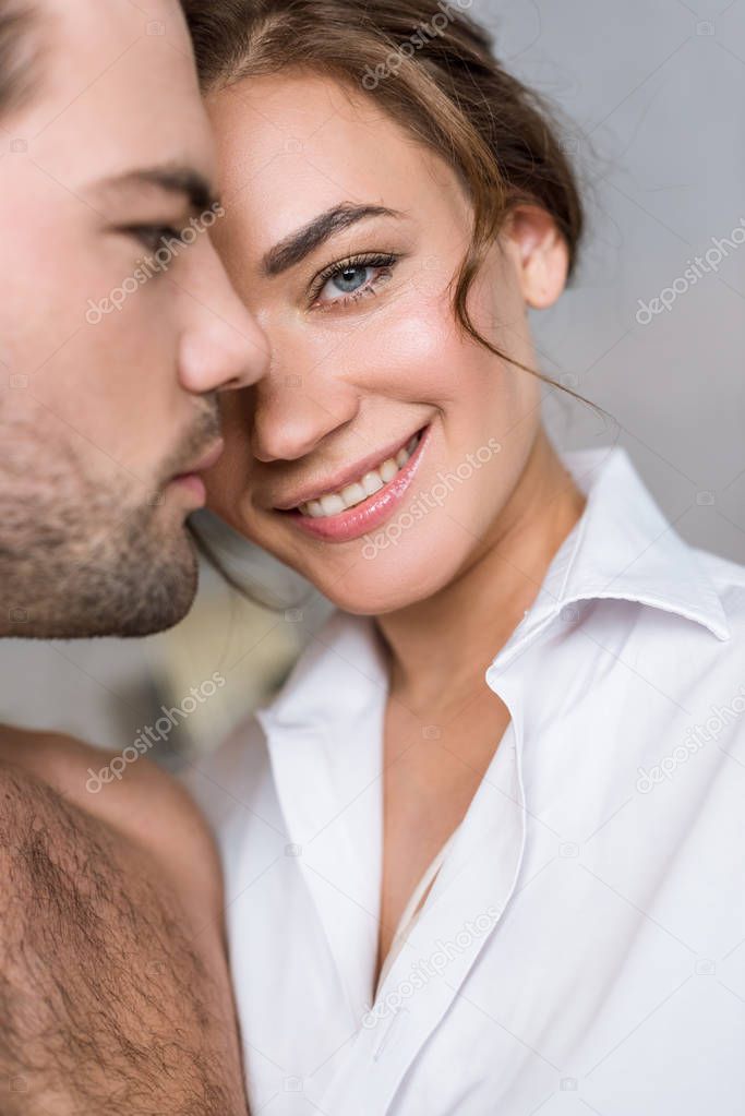 close up of attractive woman smiling near handsome boyfriend