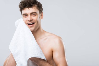 gülümseyen yakışıklı gri izole havlu ile silinerek