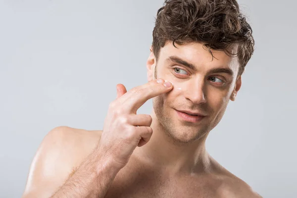 Lycklig Man Tillämpa Kosmetisk Kräm Ansiktet Isolerad Grå — Stockfoto