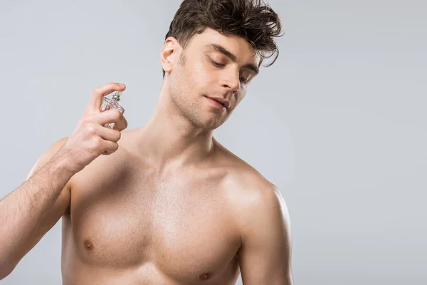 Shirtless Sexy Jongeman Spuiten Van Parfums Geïsoleerd Grijs — Stockfoto