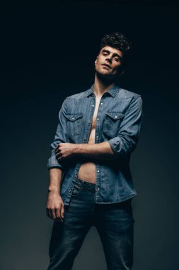 şık yakışıklı gri izole denim giysiler içinde poz