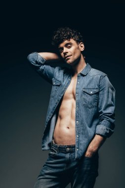 seksi maço koyu gri izole denim giysiler içinde poz