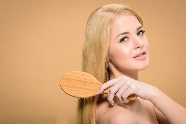 Atractiva Joven Mujer Mirando Cámara Mientras Cepilla Cabello Liso — Foto de Stock