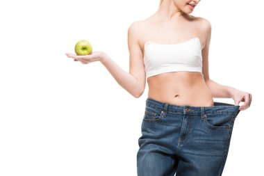 büyük boy kot üzerinde beyaz izole yeşil elma holding içinde gülümseyen ince kadın kırpılmış atış 