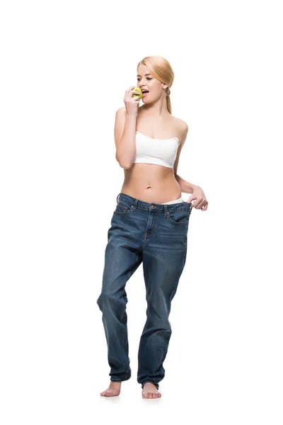 Bela Jovem Mulher Jeans Oversized Comer Maçã Verde Isolado Branco — Fotografia de Stock