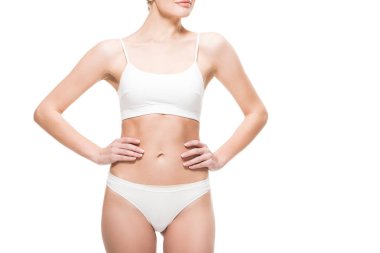 Genç ince kadın iç çamaşırı ayakta beyaz izole bel üzerinde elleriyle kırpılmış atış