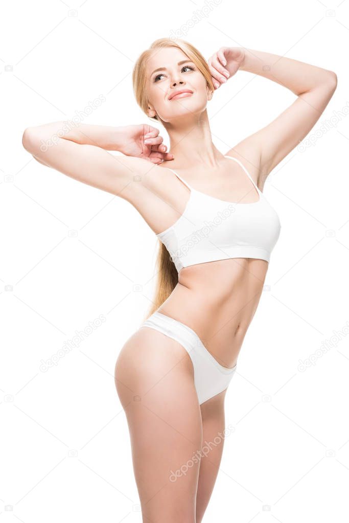 beautiful happy young woman in white underwear smiling and looking away isolated on white