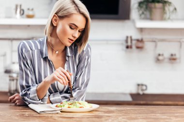 seçici odak olan çekici kadın salata yemek