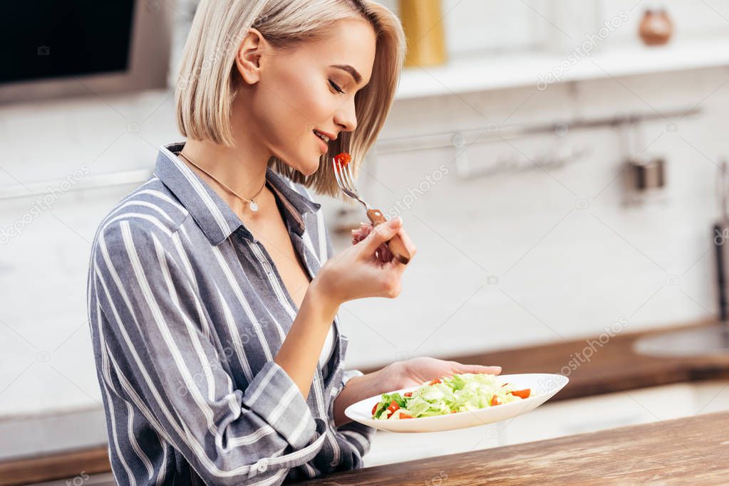 selective focus of attractive woman holding plate and eating lunch