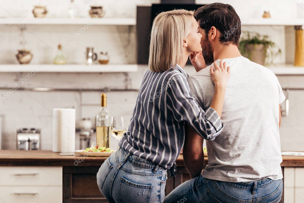 boyfriend and attractive girlfriend hugging in kitchen
