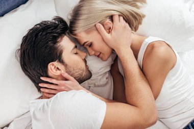 çekici kız ve yakışıklı erkek kapalı gözlerle yatakta döşeme