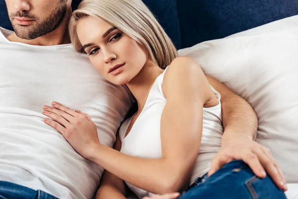 çekici kız arkadaşı ve yakışıklı erkek arkadaşı döşeme seçici odak ve kamera bakarak