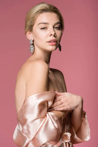Elegante Blonde Vrouw Poseren Oorbellen Zijde Gewaad Geïsoleerd Roze — Stockfoto