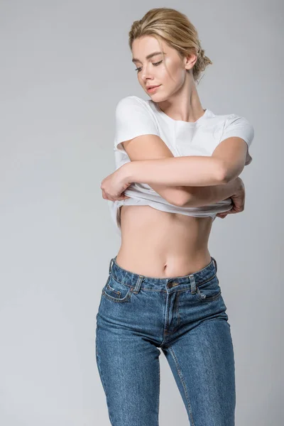 Young Woman Jeans White Shirt Undressing Isolated Grey — Stock Photo, Image