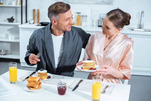 Foco Selectivo Pareja Adulta Batas Durante Desayuno Con Panqueques Jugo — Foto de Stock