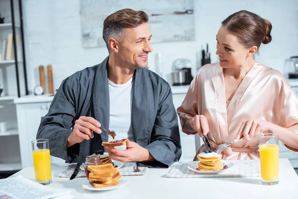 Smiling Adult Couple Robes Breakfast Pancakes Orange Juice Kitchen — Stock Photo, Image